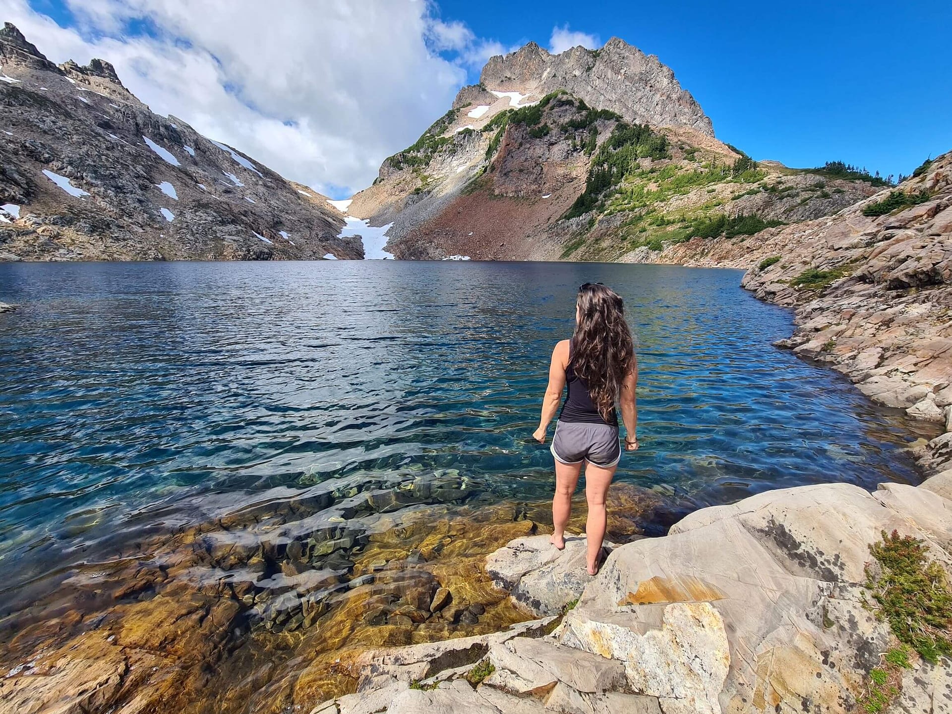 girl standing in front of Foggy Lake turquoise water